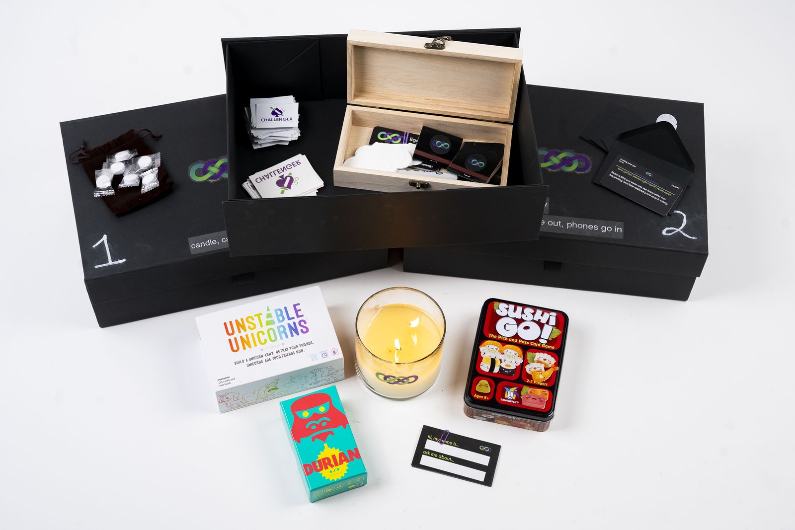 The full starter kit: three boxes, the games, candle, and materials.